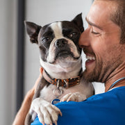 A man smiling and holding a Dog