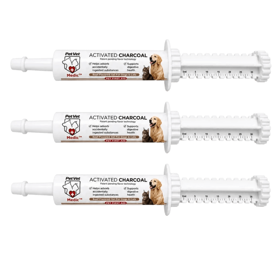 Three white PetVet Medic activated charcoal pet first aid gel syringes sit horizontally, featuring dosage measurement markings and images of a dog and cat on their labels.